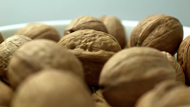 Close up walnuts rotating in the white bowl