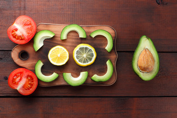 Avocado on wooden board top view, sliced avocado and lemon on wooden boards, vegetarian food, wholesome asian food, tropical fruits for breakfast, copy space