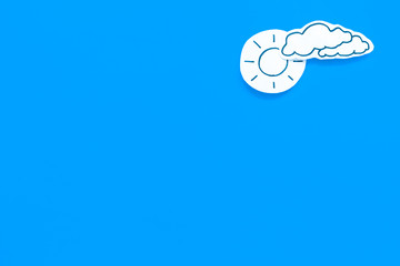 Clear and cloudly weather icons on blue background top view copy space