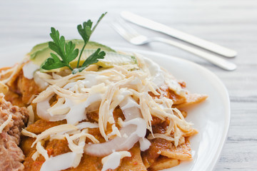 Chilaquiles rojos with chicken and avocado mexican food, breakfast in mexico city