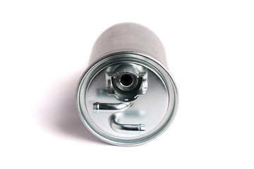 A new fuel filter enclosed in a metal casing with an inlet and outlet on fuel lines on a white isolated background