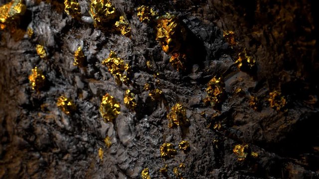 Mine wall full of gold nuggets. Treasure found in the mine. Golden ore. 4k