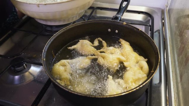 cooking for Christmas dinner: frying the zeppole - Italian Tradition