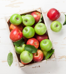 Green and red apples in wooden box