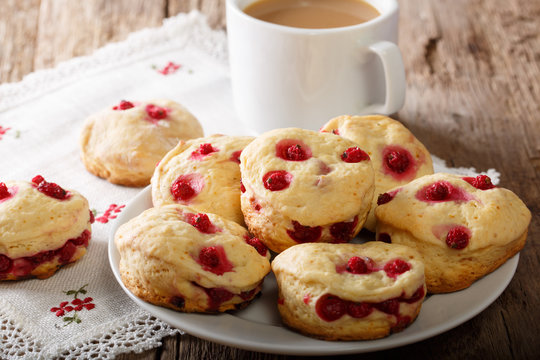 English sconces biscuits with red currants are served with tea and milk close-up. horizontal