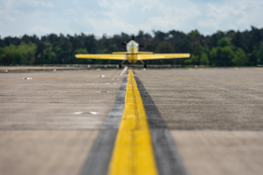 Small sports plane on the runway. Plane in blured. Focus on the foreground.