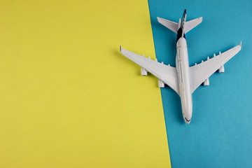 Travel concept with plane on color paper background. Copy space for text and design
