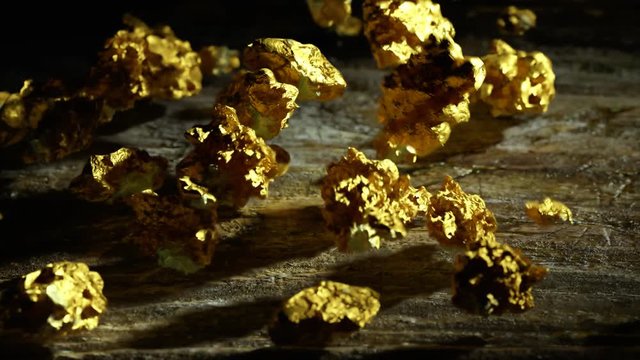 Gold nuggets are thrown on an old wooden surface. Wealth, success, treasure