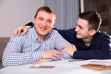 Man with his adult son are posing together
