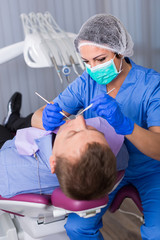 Fototapeta premium adult dentist checking teeth of patient
