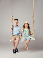 boy and girl sitting on a swing