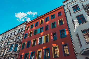 Fototapeta na wymiar colorful building between two white facaded houses