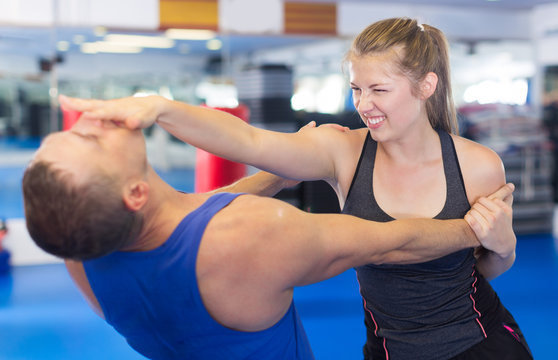 Smiling woman is fighting with trainer