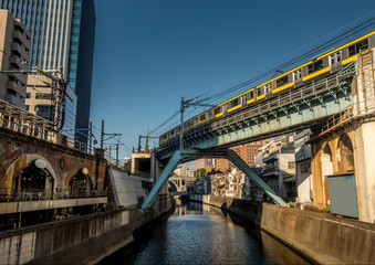Fototapeta na wymiar Tokyo train crossing a bridge over the Kanda river near Akihabara.