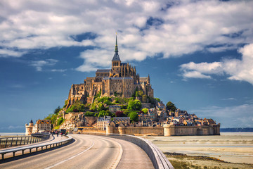 Beautiful panoramic view of famous Le Mont Saint-Michel tidal island with blue sky. Normandy,...