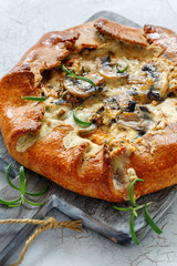 Homemade pie with mushrooms, cheese and rosemary.