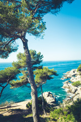 Sea view in Spain. Costa Brava holidays. Blue waves and rocks. Summertime beach.
