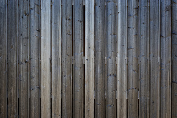 Full frame background of a gray and unpainted wood board wall with vignette