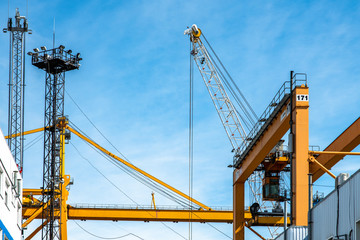 Industrial yellow cranes are waorking on blue sky background