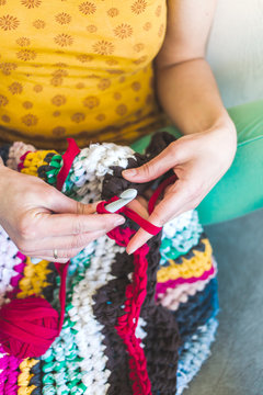The woman is crocheting.