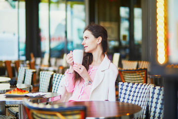 Woman drinking coffee in outdoor cafe or restaurant, Paris, France