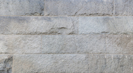 Full frame background of a wall made of big and rough stone blocks