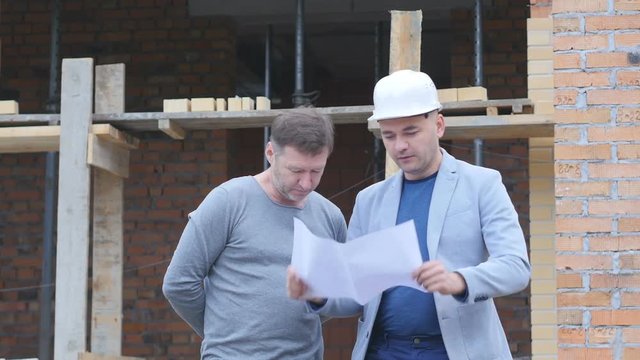 Engineer and client looking on project on the construction site