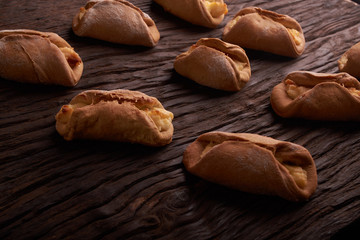 Baking cheesecakes with cottage cheese. blush baking on wooden table. sweet and tasty cookies on black background