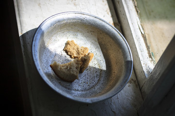 The old window from it drops sunlight. On the window an old aluminum bowl in it small pieces of...