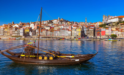 Port wine boats at the waterfront with the old town on the Douro River in Ribeira in the city centre of Porto in Porugal, Europe. Portugal, Porto - obrazy, fototapety, plakaty