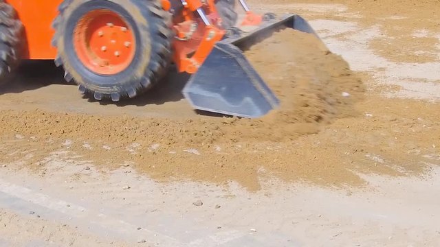 Mini-loader quickly remove soil from the surface of the asphalt.