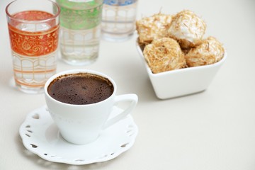Turkish coffee with Shredded dough baked in syrup topped with crushed nuts Turkish delight and cup of water