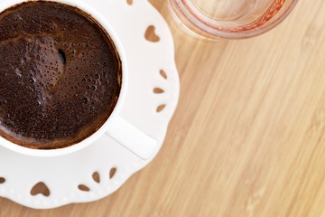 Turkish coffee with water on wood table and heart shape top view