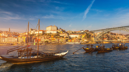 Port wine boats at the waterfront with Dom Luis bridge and the old town on the Douro River in Ribeira in the city centre of Porto in Porugal in Europe. Portugal, Porto