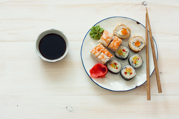 Sushi set and chopstiks on white wooden background