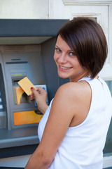 Woman withdrawing money from credit card at ATM