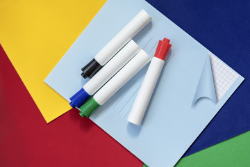 Notebook and felt-tip pens on colorful bright paper, bright background. Top view. Concept of of starting school, creature, education