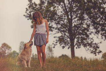 Attractive woman with her beautiful dog in nature.