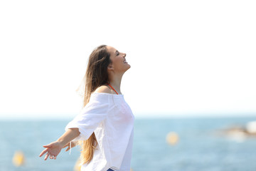 Fototapeta na wymiar Relaxed woman breathing fresh air on the beach