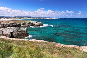 Turquoise waves of the ocean and the blue sky with clouds