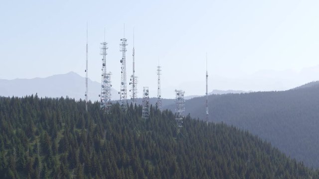 Antennas complex on a forested hill. Radio masts and towers for broadcasting.