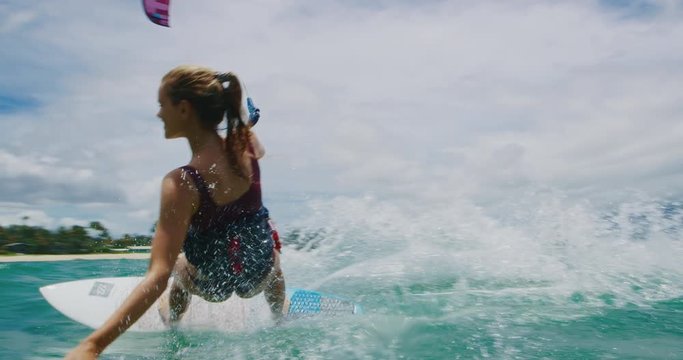 Beautiful young woman surfing, extreme sport slow motion