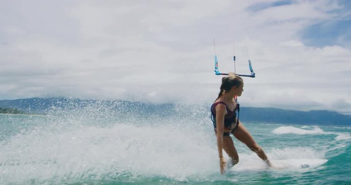 Beautiful young woman surfing, extreme sport slow motion