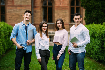 Multiethnic group of happy young students people standing in campus together outdoors