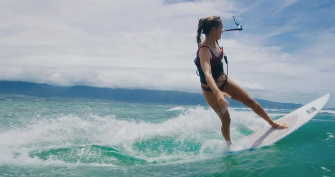 Beautiful young woman surfing, extreme sport slow motion