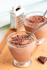Healthy dessert chocolate pudding serving cups wooden cutting boarding. Selective focus.