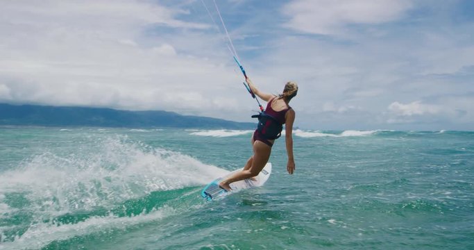 Beautiful young woman kitesurfing