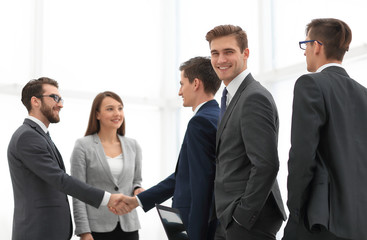 Business handshake. Two  cheerful businessman shaking hands in o