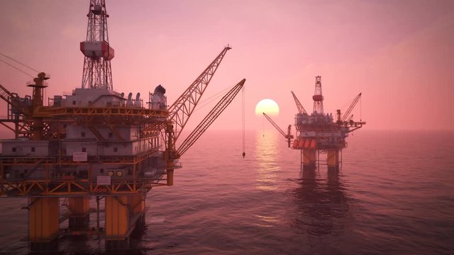 Two offshore platforms in the open sea with a pink sunset sky and a sun.