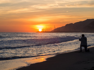 Photographer portraying sunset on the beach